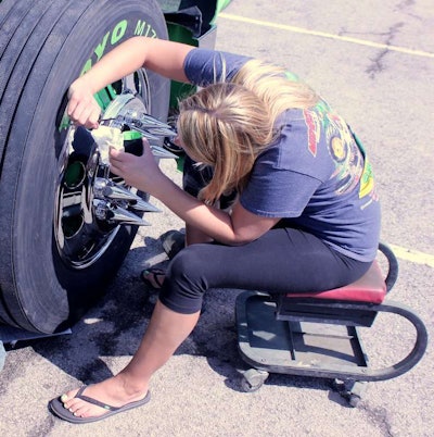 Tabitha Garrels adds a finishing touch to a truck's tires and he toes