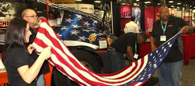 Randy Twine (right) gets help preparing the flag.