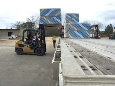 Sheetrock is unloaded from Mechigian's flatbed truck. (Photo: Deanne Winslett)