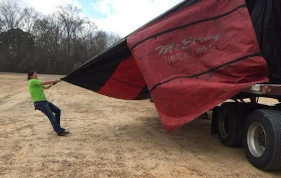 Mechigian pulls the tarp off of the sheetrock load. (Photo: Deanne Winslett)