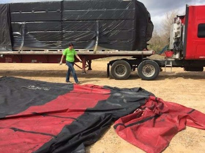 Mechigian prepares to fold and roll up the tarp. (Photo: Deanne Winslett)