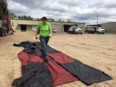 Mechigian works to roll up her tarp as the wind blows it astray. (Photo: Deanne Winslett)