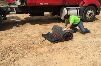 Mechigian rolls up the tarp. (Photo: Deanne Winslett)