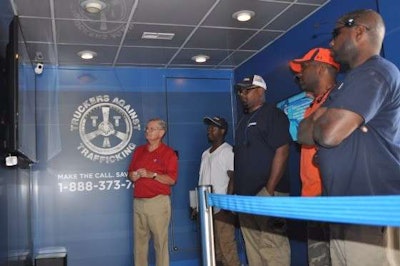 Boyd Brothers employees watch a Truckers Against Trafficking video inside the Freedom Drivers Project trailer.