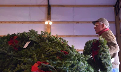 A volunteer places remembrance wreaths on a trailer so they can be distributed throughout Alabama National Cemetery.