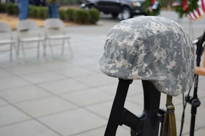 A military hat sits atop a rifle as part of the Wreaths Across America setup at Alabama National Cemetery.
