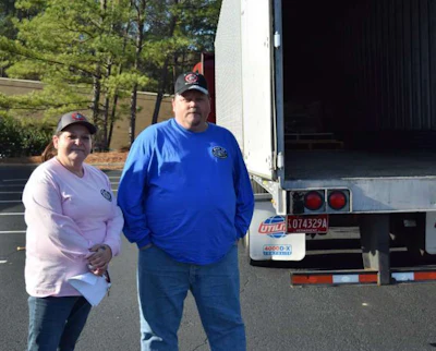Lilley and Ayscue stand beside their company truck. Lilley hauled 77 crates of wreaths to Jefferson Memorial Gardens.