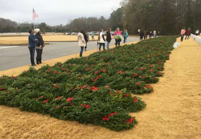 Volunteers stand ready to hand out remembrance wreaths during Wreaths Across America Day at Alabama National Cemetery.