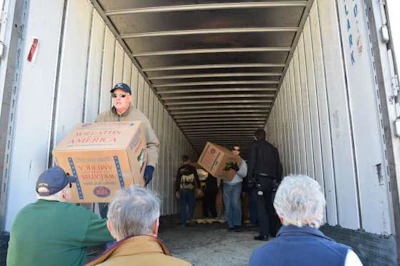 Volunteers unload boxes of remembrance wreaths off the truck at Alabama National Cemetery.