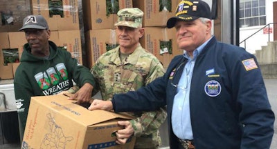 Pinnacle Freight’s Randy Scott (left) and Perdue’s Mark Dickinson (right) assist West Point Superintendent Lt. General Robert Caslen Jr. with unloading the first box of memorial wreaths.