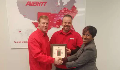 Jennifer Wade (right) of the Missouri Division of Workplace Development presents the Flag of Freedom award to Averitt Express’ St. Louis service center director Scot Hollocher (left) and driver Joseph Ailshie (center). Ailshie served in the United States Marine Corps during operations Desert Shield and Desert Storm.