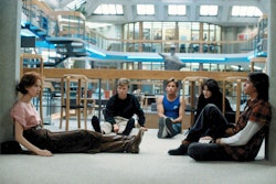 Members of the same detention class sit in a circle in a scene from The Breakfast Club. (Image Courtesy of HBO Now/Universal Pictures)