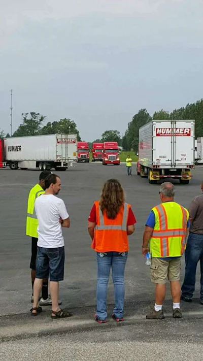 Candace Marley, pictured center in an orange vest, looks out onto her company’s training yard. (Image Courtesy of Candace Marley)