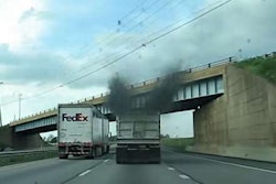 Semi truck with smog from stacks next to a FedEx truck