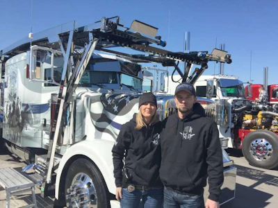Jake and Stephanie Robak stand next to their customer truck, End of Watch, at the Mid-America Trucking Show.