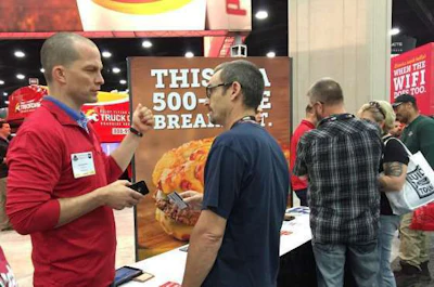 An exhibitor and attendee chat at the Pilot Flying J booth.