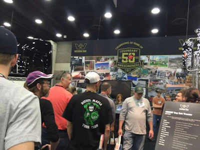 Attendees stand in line at the Western Star booth to receive a free hat and posters.