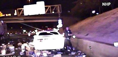 Still from dash cam shows Nevada Highway Patrol trooper dodging cans and bottles of beer on I-15.