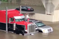 Trucker rescues a woman stranded atop her SUV in Baton Rouge.