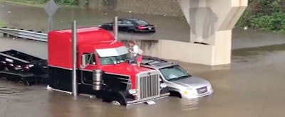 Trucker rescues a woman stranded atop her SUV in Baton Rouge.
