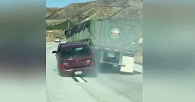 Screen shot from a video that shows a car being dragged behind a truck in California.