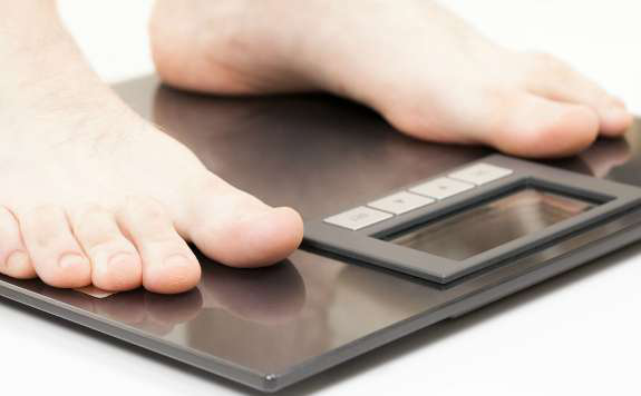 Trucker standing on a weight scale