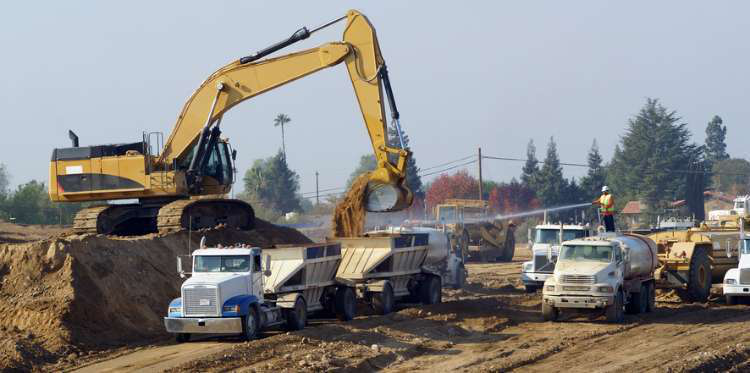 Excavator loading dirt into a truck trailer