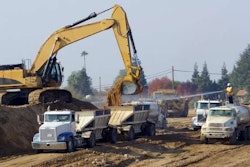 Excavator loading dirt into a truck trailer