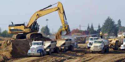 Excavator loading dirt into a truck trailer