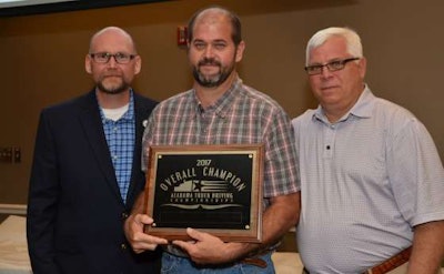 FedEx Freight driver Cecil Salter (center) accepts his TDC Grand Champion award from TDC Chairman Tony Smith (left) and ATA Chairman of the Board Gary Bond (right) at the TDC Awards Banquet.