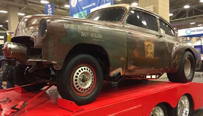 A vintage car sits on the truck bed of one of the American Truck Historical Society's displayed trucks at GATS.