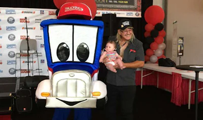 Trucker Tim Squires and his daughter, Abigail, pose with Safety Sammy at GATS.