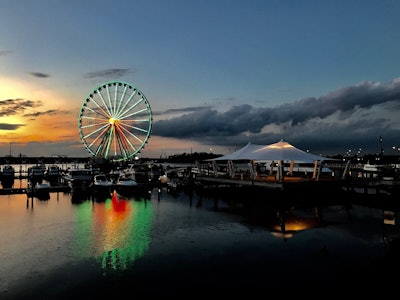 The Capital Wheel at National Harbor was lit up like a remembrance wreath with a bow, shining green and red across the Potomac Tuesday evening.