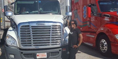 Letha Smith stands with he company Freightliner.