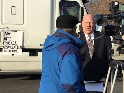 Owner/operator Douglas Hasner (right) speaks with a TV reporter at Monday’s event near Syracuse.