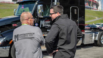 Bob Foran (left) talks with Rollins Montgomery, owner of Montgomery Transport, after being named driver of the year for the company.