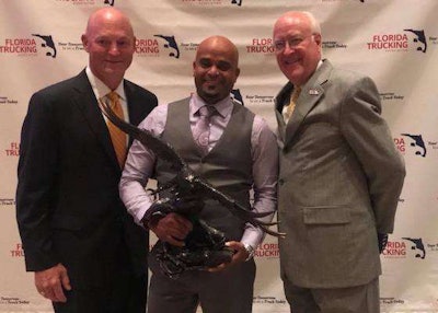 Left to Right: FTA Board Chair Rob Sandlin (Florida Rock & Tank Lines), Grand Champion Jottyn Santos (FedEx Express) and FTA President Ken Armstrong. (Image Courtesy of Florida Trucking Association)