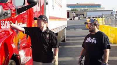 Josh England, C.R. England's president, and Chad England, the fleet's chief executive officer, conduct a pre-trip inspection before going out on a run. (Image Courtesy of C.R. England)