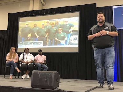 Chris Gonzalez, CRST Malone's recruiting director, speaks about Chanita Ward's story and her contributions to the fleet while she sits center with her daughter-in-law Sarah McCray, left, and her son Terrill McCray, left.