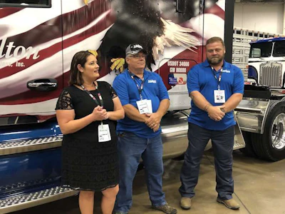 Marilyn Surber, Melton Truck Lines' employee services manager, announced David Teegarden, left, and Donnie McCuddy, right, as the winners of the trucks during GATS.