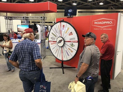 GATS attendees spin a wheel at the RoadPro booth for prizes.