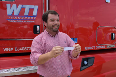 WTI Transport Vice President of Operations Josh King announces driver Liberato Lupo as the winner of the 2014 Kenworth T660.