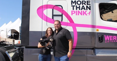 Shannon Palmer, left, and her service dog Lily stand with Werner President and CEO Derek Leather next to the Susan G. Komen Race for the Cure truck. (Image Courtesy of Werner Enterprises)