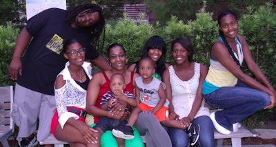 Yvonne Perry and her children, from left to right: Robert Hardwick, Alexus Robson, Yvonne, Ethan Perry in Yvonne’s lap, Ashley Cunningham, Elijah Perry in Ashley’s lap, Angel Robson, and Samantha Cunningham. Perry’s trucking company is named after her children.