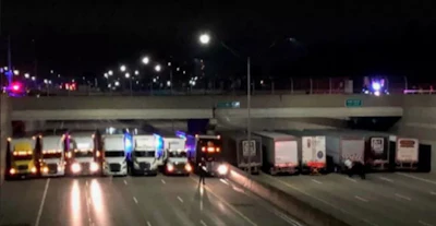 13 tractor-trailers lined up shoulder to shoulder under an overpass on Interstate 696 near Detroit to thwart a person's suicide attempt in April.
