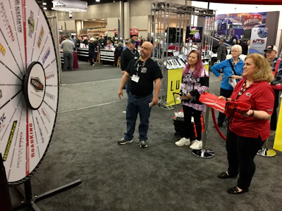A MATS attendee and Kim McDonnell (right) watches the prize wheel spin at the RoadPro booth