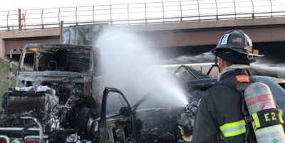 A firefighter sprays water on the wreckage of Thursday’s crash on I-70 in Denver. (Lakewood Fire Department photo)