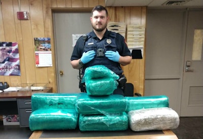 Carthage Police Officer David Fitts with the 86 pounds of marijuana seized during the arrest. (Carthage Police photo)