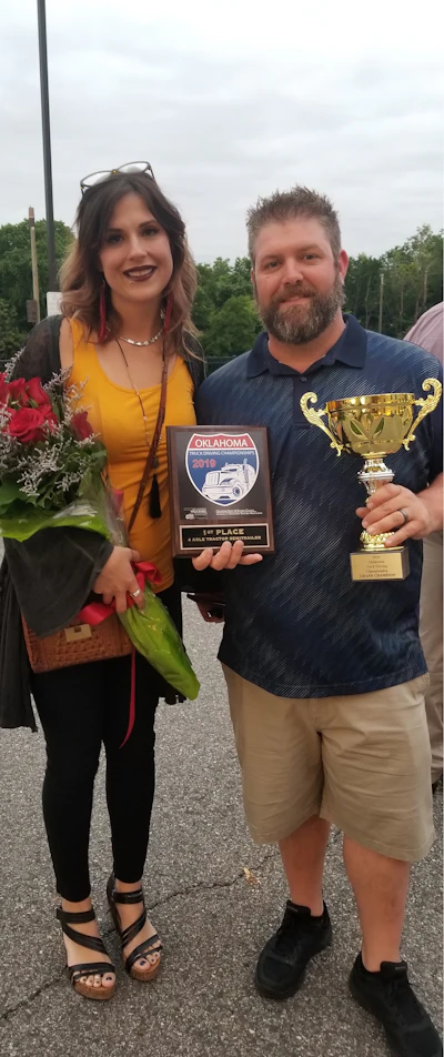 Nick Arnold, right, and his wife Renee, left, celebrate his grand champion win. (Image Courtesy of Oklahoma Truck Driving Championship)