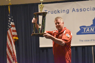 RIST Transport Ltd. driver Marty McMahon celebrates his grand champion win. (Image Courtesy of Trucking Association of New York)